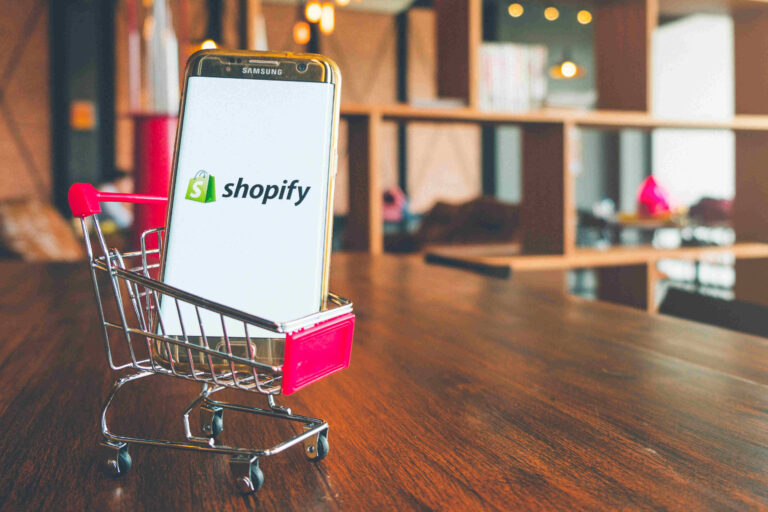 Ecommerce Shopify on a mobile phone in a mini shopping trolley in a store