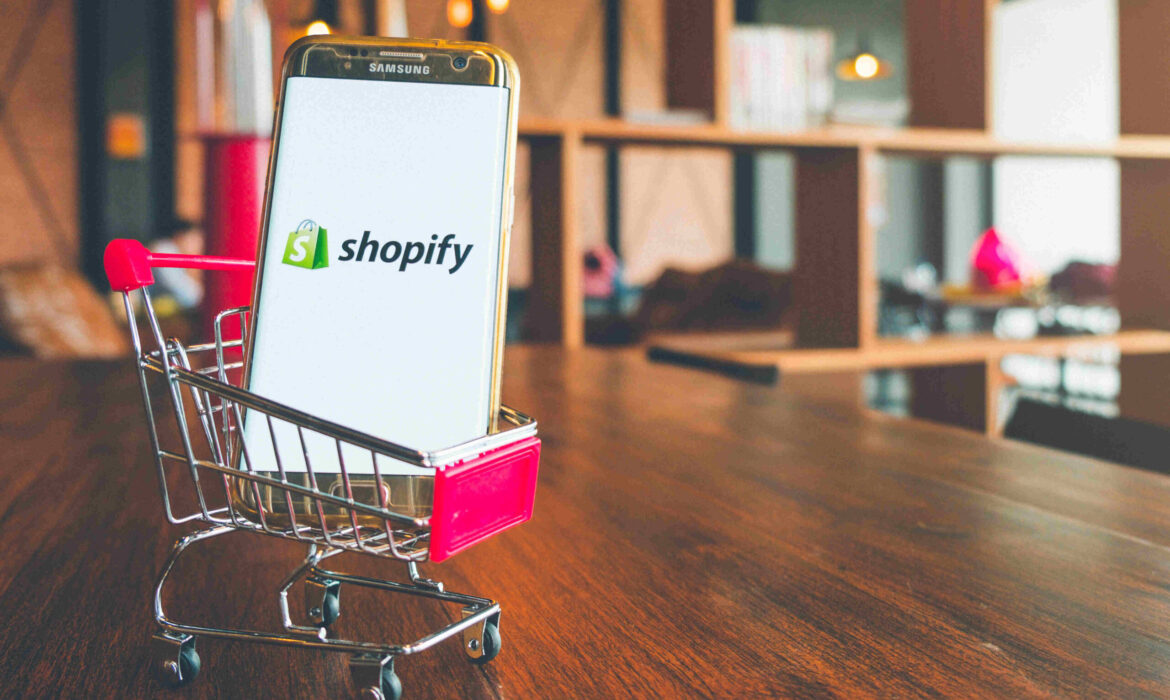 Ecommerce Shopify on a mobile phone in a mini shopping trolley in a store