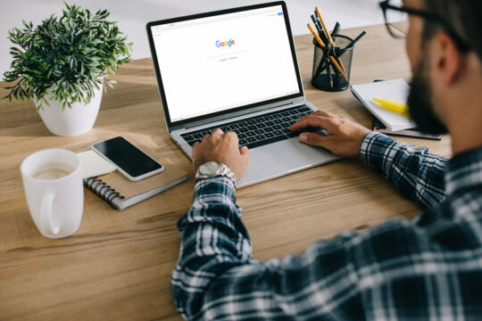 Laptop on desk with Google Search bar on screen